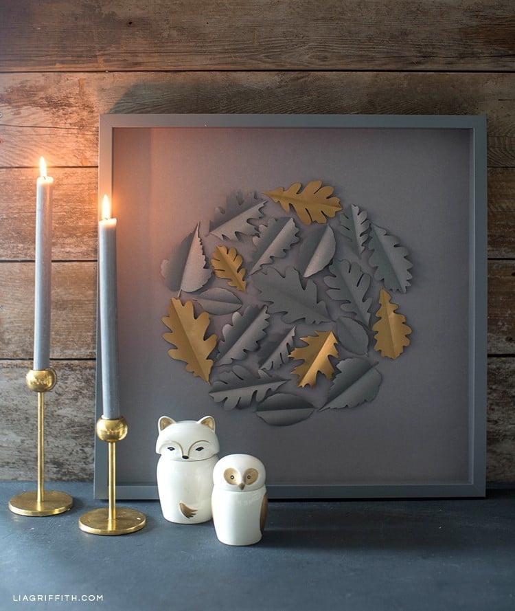 Papercut oak leaf framed art on mantle next to candles